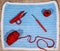 Flatlay, blue crocheted cloth and red utensils for handiwork hob