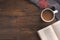 Flatlay composition with knitted scarf, cup of coffe, book, and yellow leaves on wooden desk table