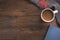 Flatlay composition with knitted scarf, cup of coffe, book, and yellow leaves on wooden desk table