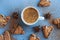 Flatlay of cup of coffee with brown cookies and star anise