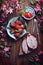 Flatlay food background - empty wooden board with dragon fruit, strawberries and pink flowers, copy space