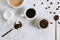 Flatlay of fresh cups of espresso and milk coffee, creamer, coffee beans and spoon on marble background