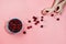 Flatlay with fresh organic cherries in blue bowl and woman`s hands picking up a berry on pink