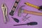 Flatlay of Hand Tools Purple Background Including Hammer, Nails, Tape Measure, Level, Screwdrivers