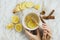 Flatlay of healthy drink with lemon, fresh ginger root, cinnamon sticks and agave syrup on marble