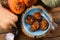 Flatlay of healthy vegetarian dish. Pumpkin pancakes in blue plate on wood slab served with onion and raw pumpkins on rustic wood