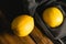 Flatlay, lemons on a cutting board and in a fruit net on a dark background. Earth day and zero waste concept