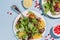 Flatlay of two citrus salad plates  with pomegranate seeds, nut and olive oi