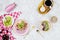 Flatlay of vegan breakfast with plant based yogurt bowls topped with kiwi slices, granola, chia seeds, smoothie bottle and coffee