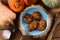 Flatlay of vegetarian meal. Pumpkin pancakes on wood slab decorated with raw onion and pumpkins on rustic wooden background