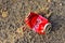 Flattened Coca-Cola can on the ground. Discarded disposable Coca Cola can. Crumpled empty single use Fizzy Drink Coke can.