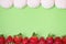 Flavored strawberries and vanilla zephyr on green background