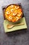 Flavorful Spanish yellow rice and shrimp with vegetables and spices closeup on the plate. Vertical top view