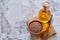 Flax seeds in bowl and flaxseed oil in glass bottle on light textured background, top view, close-up, selective focus