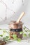 Flax seeds in glass jar with wooden spoon and natural elements leaves and bark on grey background