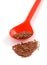 Flax seeds in plastic spoon on white background close-up