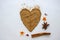 Flaxseed flour lies on a white backgruond in the form of a heart with a cinnamon stick