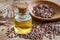 Flaxseed oil in bottle and brown flax seeds on wooden spoon