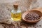 Flaxseed oil in bottle and brown flax seeds on wooden spoon