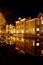 Fleet of boats in a canal in front of a picturesque row of houses at night: Leiden