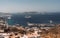 Fleet of boats near a tranquil coastal bay, situated at the base of a green hillside