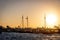 Fleet of boats silhouetted against the horizon as the sun sets, creating a beautiful orange sky