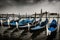 Fleet of Gondolas on Canal Grande in Venice. Black and white with accent blue