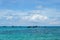 Fleet of small vessels moored in the tranquil blue waters of a picturesque shoreline