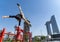 Flexible Acrobat keep balance with one hand on the fireman hydrant with blurred Dubai cityscape. Concept of modern and