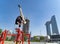 Flexible Acrobat keep balance with one hand on the fireman hydrant with blurred Dubai cityscape. Concept of modern and