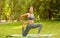 Flexible Asian lady stretching her leg on yoga mat at park on sunny day