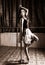 Flexible ballet dancer stretching in retro style. Ballerina dances near pole