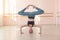 Flexible Caucasian girl stands on her head in a dance class. The girl does yoga. . Woman dancing breakdance on the