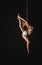 Flexible dancer exercising on pole in studio