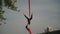 Flexible female acrobat doing crazy and dangerous trick on red aerial silk the sunset sky background is slow motion