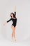 Flexible female in black bodysuits, ballet dancer, white studio shot