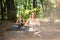 Flexible female doing yoga in forest