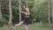 Flexible female gymnast doing acrobatic tricks in the park, slow motion