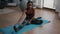 Flexible fit black woman doing stretching routine on yoga map