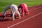 Flexible girls gymnasts stand in crab position on athletics track, flexibility