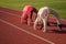 Flexible girls gymnasts stand in crab position on athletics track, flexibility