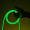 Flexible green led tape neon in hand on black background