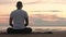 Flexible man in lotus pose meditating on the beach