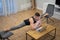Flexible man work on laptop and doing leg-split at home. Concept of willpower, motivation and passion