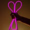 Flexible purple led tape neon in hand on black background