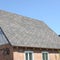 Flexible shingles of bitumen roofing surface on the brick house