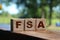 Flexible spending account FSA written on a wooden cubes. Financial concept