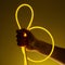 Flexible yellow led tape neon in hand on black background