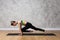 Flexible young girl in yoga Plank pose on a mat against the wall