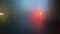 Flickering headlights of a car through a fogged wet glass